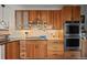 Modern kitchen featuring custom wood cabinetry, stainless appliances, and tile backsplash at 7192 Pinewood Dr, Evergreen, CO 80439
