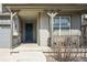 Charming covered front porch with a blue door and grey siding at 8503 Estes Park Ave, Littleton, CO 80125