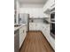 Modern kitchen with stainless steel appliances, white cabinetry, granite countertops, and hardwood floors at 8503 Estes Park Ave, Littleton, CO 80125