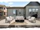 Back patio with modern outdoor furniture and a fire pit at 8503 Estes Park Ave, Littleton, CO 80125