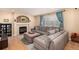 Comfortable living room with a fireplace, large sectional sofa, and natural light from the window at 3101 Goldeneye Pl, Superior, CO 80027