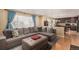 Inviting living room featuring a large sectional sofa, ottoman, and a seamless transition to the kitchen at 3101 Goldeneye Pl, Superior, CO 80027