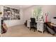 Well-lit office with built-in bookshelves, white desk, and guitar at 3101 Goldeneye Pl, Superior, CO 80027