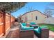 Backyard featuring artificial turf, brick patio, outdoor seating, and a wooden deck at 8001 W 57Th Ave, Arvada, CO 80002