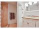 Cozy bathroom featuring stone-tiled shower, vanity with storage, and modern fixtures at 8001 W 57Th Ave, Arvada, CO 80002