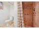Bathroom showcasing tiled walk-in shower with glass door and nearby toilet at 8001 W 57Th Ave, Arvada, CO 80002