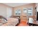 Cozy bedroom featuring hardwood floors, workspace with desk, chair, and large double windows at 8001 W 57Th Ave, Arvada, CO 80002