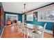 Bright dining room with natural light, featuring hardwood floors, a wooden table, and blue accent walls at 8001 W 57Th Ave, Arvada, CO 80002