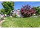 Charming home boasts a lush lawn, mature trees, and a 'For Sale' sign on the property at 8001 W 57Th Ave, Arvada, CO 80002