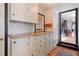 Hallway with hardwood floors, storage, and access to kitchen at 8001 W 57Th Ave, Arvada, CO 80002