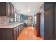 An updated kitchen featuring light hardwood floors, stainless steel appliances, and blue cabinets at 8001 W 57Th Ave, Arvada, CO 80002