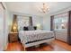 Light-filled main bedroom with hardwood floors, a chandelier, and large windows at 8001 W 57Th Ave, Arvada, CO 80002