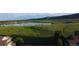 Scenic aerial view highlighting the green space, lake, and mountain views within the community at 12743 W Bowles Pl, Littleton, CO 80127