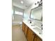 Bright bathroom with double sinks, modern fixtures, and a framed mirror complements a bathtub at 12743 W Bowles Pl, Littleton, CO 80127