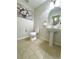 Well-lit powder bathroom with white fixtures and a stylish pedestal sink at 12743 W Bowles Pl, Littleton, CO 80127