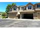 Exterior view of townhomes with two-car attached garages and mature landscaping at 12743 W Bowles Pl, Littleton, CO 80127