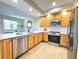 Modern kitchen with stainless steel appliances, stone counters, and stylish wood cabinets at 12743 W Bowles Pl, Littleton, CO 80127