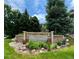 Community entrance sign with stone base and mature landscaping at 12743 W Bowles Pl, Littleton, CO 80127