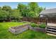 Backyard with garden beds, a deck, and a lush green lawn at 1672 Maccullen Dr, Erie, CO 80516