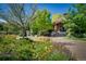 Brick clubhouse amidst green trees and colorful flowers with a walkway and mature landscaping at 1672 Maccullen Dr, Erie, CO 80516