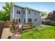 Charming two-story home with a wooden deck, landscaped yard, and beautiful blue siding at 1672 Maccullen Dr, Erie, CO 80516