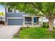 Inviting two-story home with a blue front door, covered porch, beautiful landscaping, and an attached two-car garage at 1672 Maccullen Dr, Erie, CO 80516