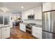 Modern kitchen features stainless steel appliances, double oven, white cabinets, and beautiful hardwood floors at 1672 Maccullen Dr, Erie, CO 80516