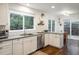 Bright kitchen with white cabinets, stainless steel appliances, hardwood floors and large windows at 1672 Maccullen Dr, Erie, CO 80516