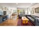 Open-concept living room boasts hardwood floors, a large window, and views of the kitchen and dining area at 1672 Maccullen Dr, Erie, CO 80516