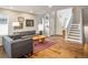 Comfortable living room featuring hardwood floors, neutral paint, and access to the staircase at 1672 Maccullen Dr, Erie, CO 80516