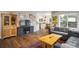 Spacious living room with hardwood floors, stylish decor, and an open layout flowing into the kitchen at 1672 Maccullen Dr, Erie, CO 80516