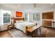 Bright main bedroom features hardwood floors, natural light, and rustic wood furniture at 1672 Maccullen Dr, Erie, CO 80516