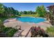 Outdoor swimming pool with lane markers, surrounded by a concrete deck and lush green trees at 1672 Maccullen Dr, Erie, CO 80516