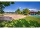 Sand volleyball court near a pool and clubhouse, with lush green trees and a blue sky backdrop at 1672 Maccullen Dr, Erie, CO 80516