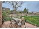 Inviting backyard featuring a brick patio with a table and chairs, grassy area, and wooden fence at 3633 S Ingalls St, Denver, CO 80235