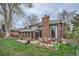 Brick patio with an outdoor dining set in a spacious backyard with mature trees at 3633 S Ingalls St, Denver, CO 80235