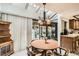 Dining area with a round wooden table, chandelier, and backyard view at 3633 S Ingalls St, Denver, CO 80235