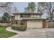 Two-story home with a brick facade, tudor accents, a driveway and a two-car garage at 3633 S Ingalls St, Denver, CO 80235