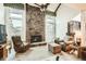 Spacious living room with a stone fireplace, large windows, and vaulted ceiling at 3633 S Ingalls St, Denver, CO 80235