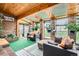 Bright sunroom featuring brick walls, wood ceilings, skylights, and comfortable seating, with a garden view at 3633 S Ingalls St, Denver, CO 80235