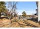 Spacious backyard with mature trees, playground equipment, and patio area at 6367 Arapahoe Ct, Parker, CO 80134