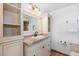 Bathroom featuring custom cabinets, granite counters, and traditional vanity lighting at 6367 Arapahoe Ct, Parker, CO 80134