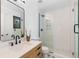 Updated bathroom with a glass-enclosed shower, wood vanity, modern fixtures, and a stylish star-patterned tile floor at 6367 Arapahoe Ct, Parker, CO 80134