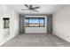 Large bedroom with a neutral color scheme, a ceiling fan, gray drapes, and a window offering a neighborhood view at 6367 Arapahoe Ct, Parker, CO 80134