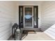 Close-up of front door with storm door and side windows, complemented by a decorative lantern and 
