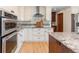 Renovated kitchen showcasing granite countertops, white cabinetry, and a stainless steel oven and range hood at 6367 Arapahoe Ct, Parker, CO 80134