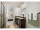 Bathroom with dual sink vanity, framed mirror, bronze fixtures, and view into the bedroom at 4089 Forever Cir, Castle Rock, CO 80109