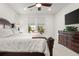 Bright bedroom featuring neutral walls, ceiling fan, and dresser with mounted television at 4089 Forever Cir, Castle Rock, CO 80109