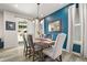 Dining area featuring a blue accent wall with white curtains, a wooden table and a modern chandelier at 4089 Forever Cir, Castle Rock, CO 80109