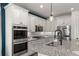 Modern kitchen featuring white cabinets, granite countertops, a large island, and stainless steel appliances at 4089 Forever Cir, Castle Rock, CO 80109